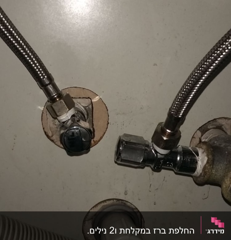צינורות מתכת מחוברים לשסתומים בקיר